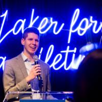 Alumni speaker talks from podium at Toast